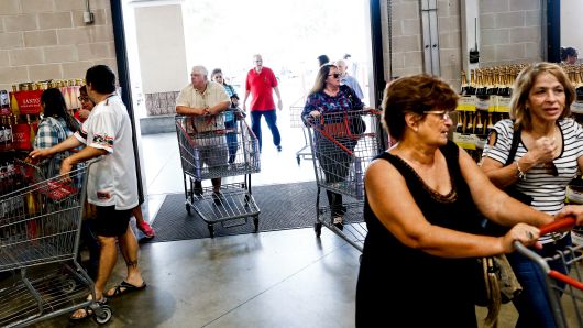Customers push shopping carts while entering a Costco Wholesale store in Miami, Florida.