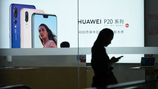 A Huawei poster is displayed in a store in Beijing on August 7, 2018.