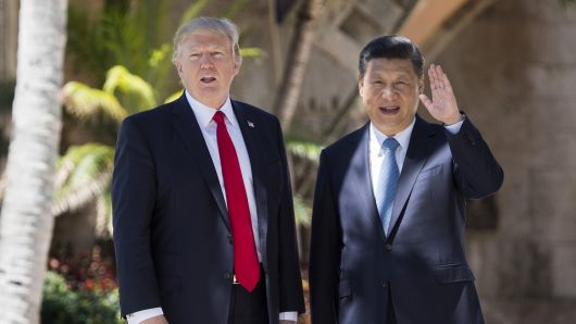 Chinese President Xi Jinping (R) waves to the press as he walks with US President Donald Trump at the Mar-a-Lago estate in West Palm Beach, Florida, April 7, 2017.