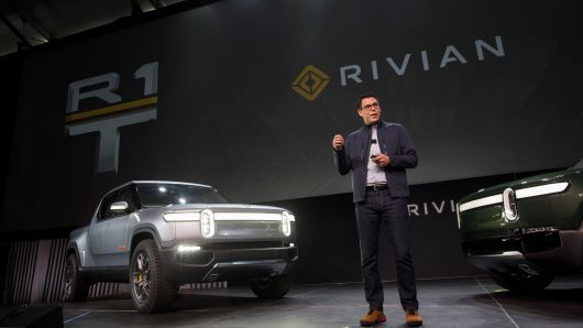 RJ Scaringe, founder and chief executive officer of Rivian Automotive Inc., unveils the R1T electric pickup truck, left, and R1S electric sports utility vehicle (SUV) during a reveal event at AutoMobility LA ahead of the Los Angeles Auto Show in Los Angeles, California.