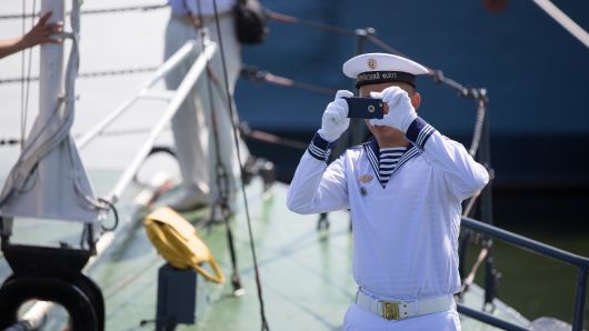A Baltic Fleet sailor takes a photograph with a smartphone during Russian Navy day at the Vistula lagoon in Baltiysk, Russia, on July 31, 2016.