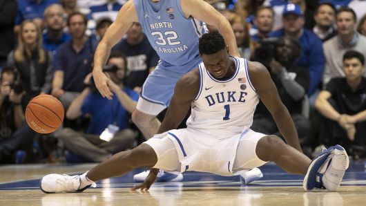 Duke's Zion Williamson (1) falls to the court under North Carolina's Luke Maye (32), injuring himself and damaging his shoe during the opening moments of the game in the first half on Wednesday, Feb. 20, 2019, at Cameron Indoor Stadium in Durham, N.C.