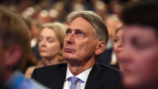Britain's Chancellor of the Exchequer Philip Hammond waits for Britain's Prime Minister Theresa May to give her keynote address on the fourth and final day of the Conservative Party Conference 2018 at the International Convention Centre in Birmingham, central England, on October 3, 2018.
