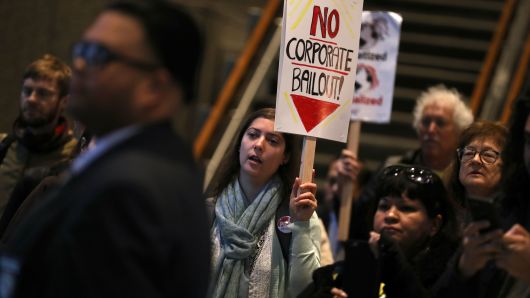 Protesters hold signs as they stage a demonstration inside the lobby of the Pacific Gas and Electric (PG&E) headquarters on December 11, 2018 in San Francisco, California.