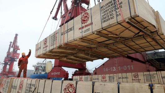 A worker gestures as a crane lifts goods for export onto a cargo vessel at a port in Lianyungang, Jiangsu province, China February 13, 2019.