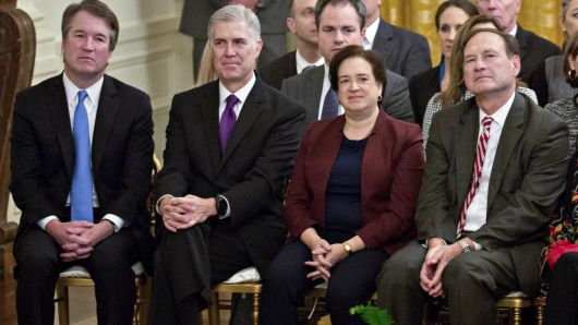 Associate Justices of the Supreme Court including Brett Kavanaugh, from left, Neil Gorsuch, Elena Kagan Samuel Alito Jr., Ruth Bader Ginsburg and Chief Justice John Roberts, listen during a Presidential Medal of Freedom ceremony in the East Room of the White House in Washington, D.C., U.S., on Friday, Nov. 16, 2018.
