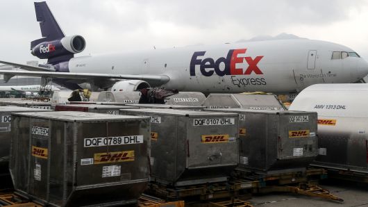 DHL containers and a FedEx airliner at Hong Kong International Airport, in the Hong Kong Special Administrative Region (HKSAR) of the People's Republic of China.
