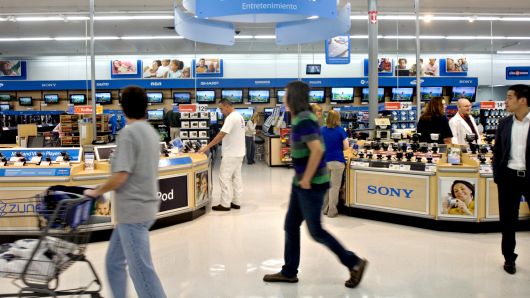 Shoppers walk past the entertainment and electronics section in a Wal-Mart Supercenter store in Rogers, Arkansas.