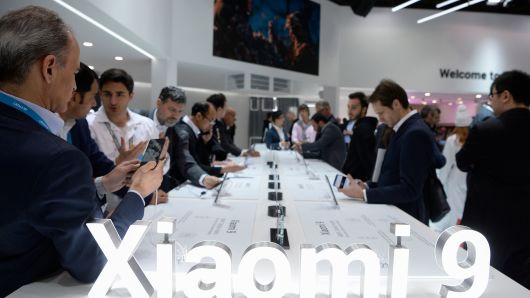 Visitors test the new Xiaomi Mi 9 smartphone at the Mobile World Congress (MWC) in Barcelona on February 27, 2019.