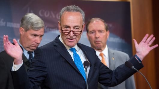 Senator Charles Schumer (D-NY) speaks as Senators Sheldon Whitehouse (D-RI), left, and Tom Udall (D-NM), right, listen during a news conference in the U.S. Capitol building on June 23, 2016 in Washington, DC.