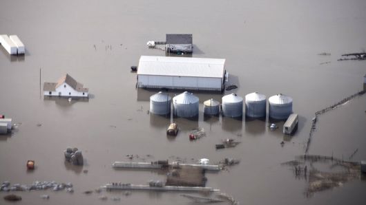 This Monday, March 18, 2019 file photo shows flooding and storage bins under water on a farm along the Missouri River in rural Iowa north of Omaha, Neb.